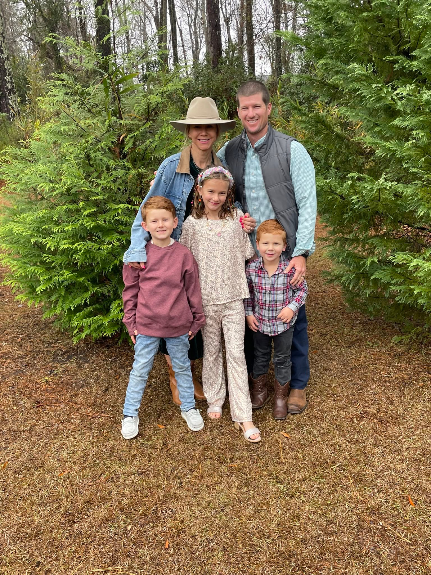 John Letsen with his wife and their three children among evergreen trees