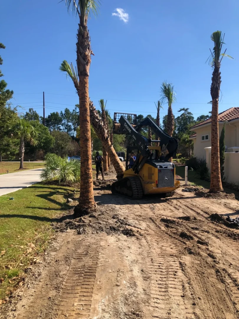 A yellow and black tractor is parked in the dirt