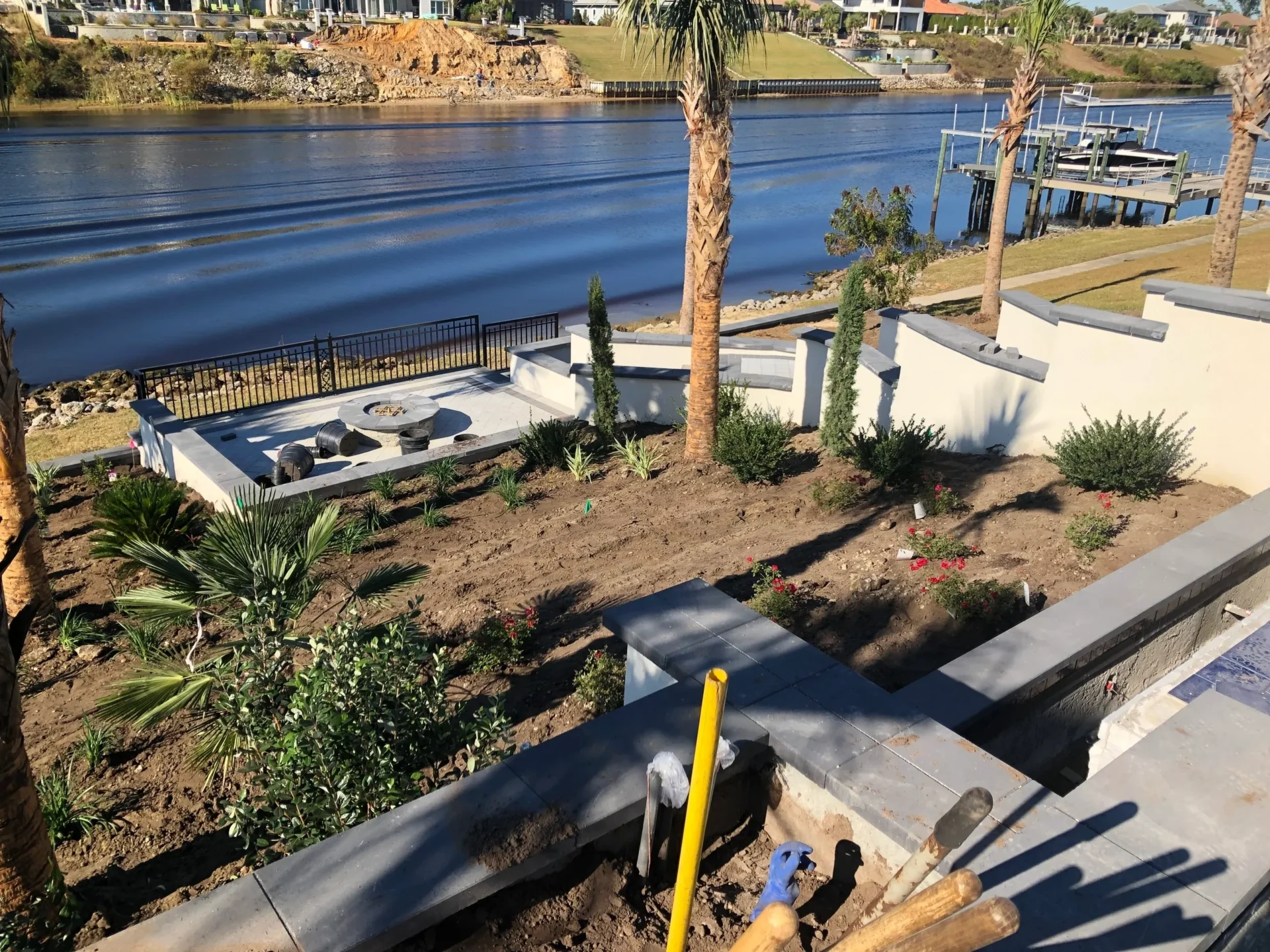 A view of the water from above shows a boat dock, palm trees and a walkway.